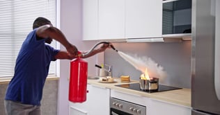 bigstock-Man-Using-Fire-Extinguisher-To-473275665-1